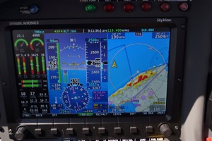 Primární obrazovka při letu kolem severního pobřeží Mallorky. Červené plošky na mapě zobrazují terén, který je výše než letadlo a žluté cokoliv, co je níže jen o 30-300 metrů (tzn. varování).