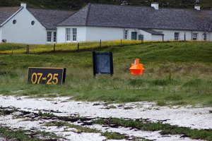 The threshold of runway 7 is marked by the orange marker
