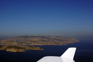 Vlevo v popředí ostrůvek Sesklio a za ním ostrov Symi. Na horizontu pak turecká pevnina.