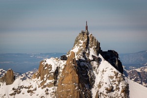 Aiguille du Midi na jehož levé straně je vidět horní stanice lanovky z Chamonix a na  straně jsou vidět její lana.