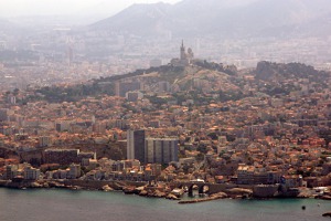 Pohled na Marseille při přeletu Marseillského zálivu. Na kopci se tyčí dominanta města - kostel Notr Dame de la Garde dokončený v roce 1864